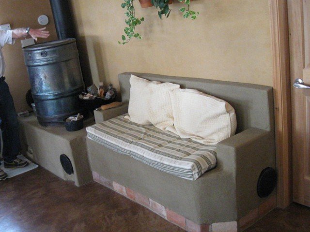 Here is their finished stove just a month later with the final coat of cob and the cushions.