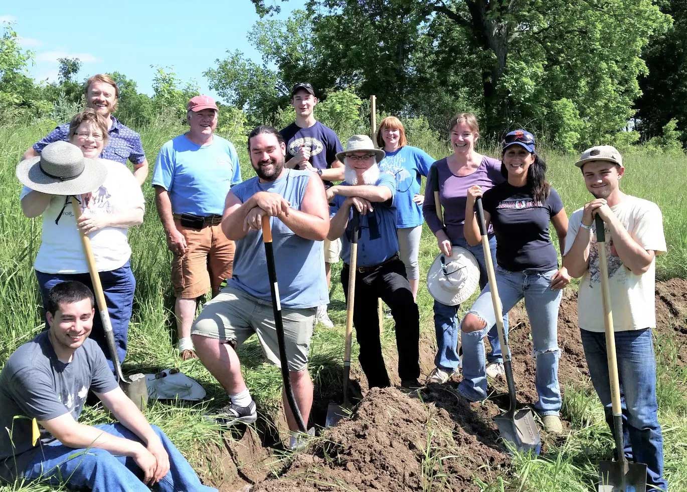 Permaculture students from our Grand Rapids PDC posing by their recently dug swale.
